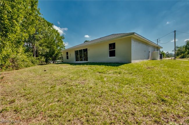 Rear view of house with stucco siding and a yard | Image 50