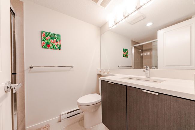 Bathroom with a baseboard radiator, vanity, a shower with door, and recessed lighting | Image 25