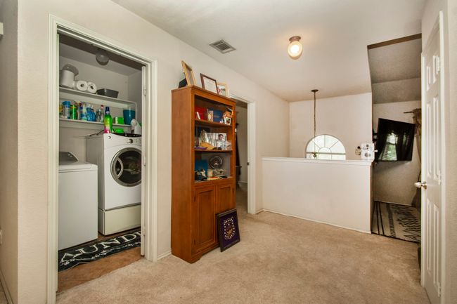Laundry room featuring washer and dryer and light carpet | Image 23