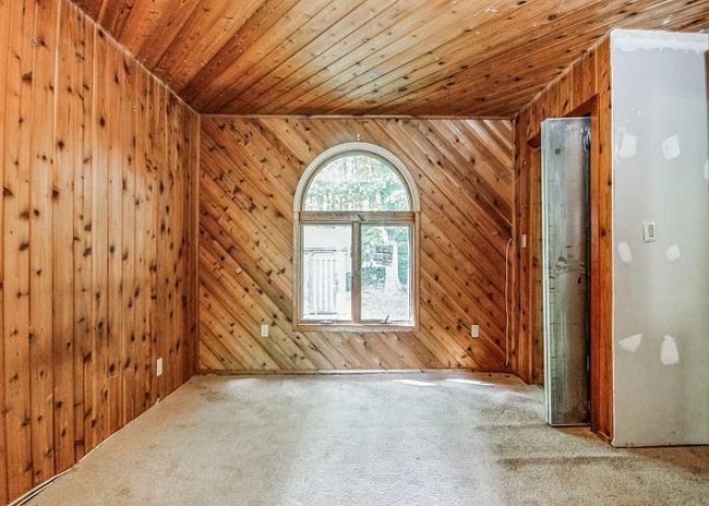 Unfurnished room featuring wood ceiling, wooden walls, lofted ceiling, and carpet floors | Image 17