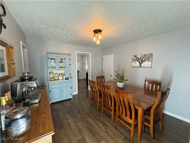 Dining area featuring dark wood finished floors and a textured ceiling | Image 12