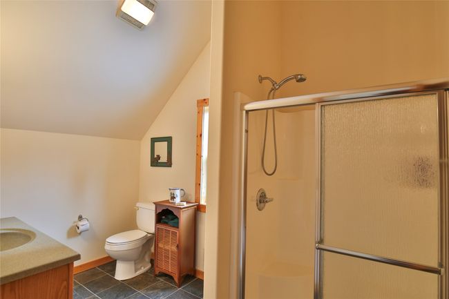 Bathroom with toilet, lofted ceiling, a shower stall, baseboards, and vanity is the upstairs suite | Image 31