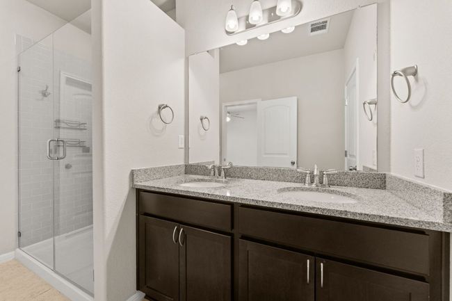Bathroom with double vanity, a stall shower, a ceiling fan, and tile patterned floors | Image 12
