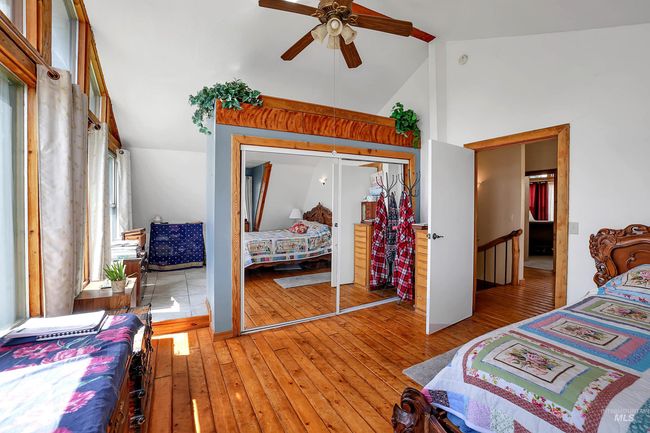 Bedroom with wood-type flooring, a closet, ceiling fan, and high vaulted ceiling | Image 23
