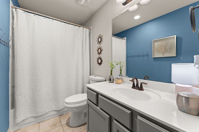 Bathroom with vanity, toilet, tile patterned floors, and shower / tub combo | Image 20