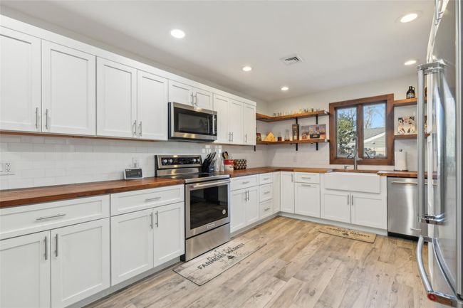 Kitchen with wood counters, open shelves, a sink, and stainless steel appliances | Image 16