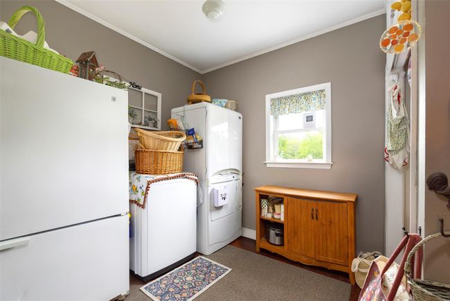 Washroom with water heater, ornamental molding, and washing machine and clothes dryer | Image 9