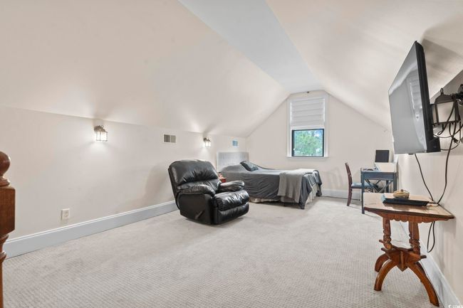 Carpeted bedroom with vaulted ceiling and baseboards | Image 26