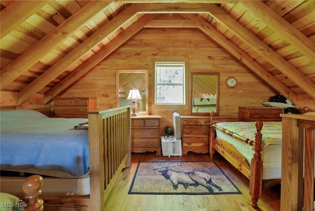 Bedroom with wooden walls, wooden ceiling, and hardwood / wood-style flooring | Image 21