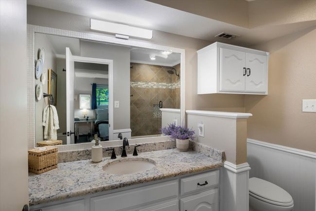 Ensuite bathroom featuring vanity, toilet, a stall shower, visible vents, and​​‌​​​​‌​​‌‌​‌‌​​​‌‌​​‌‌​‌​​​​​‌ wainscoting | Image 23