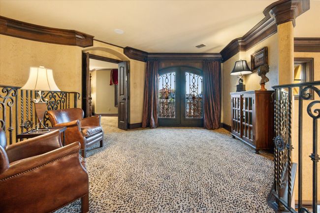 Living area with ornamental molding, baseboards, carpet floors, french doors, and arched walkways | Image 28