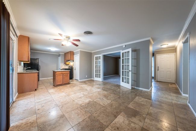 Unfurnished living room with french doors, crown molding, and ceiling fan | Image 14