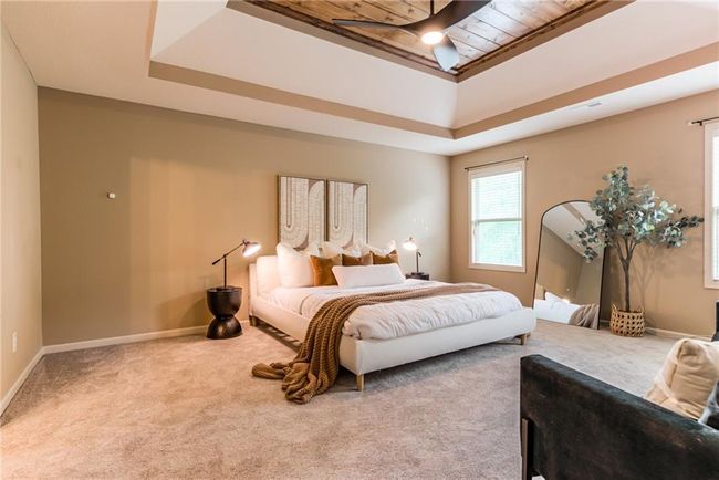 Carpeted bedroom featuring a tray ceiling and baseboards | Image 23