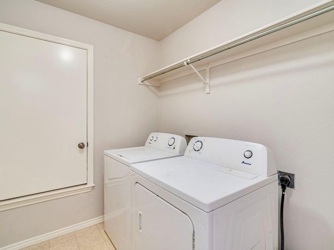 Laundry room with washing machine and dryer and light tile patterned floors | Image 16