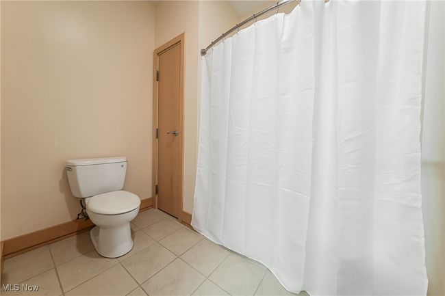 Bathroom featuring tile flooring, storage, and tub/shower combo. | Image 31