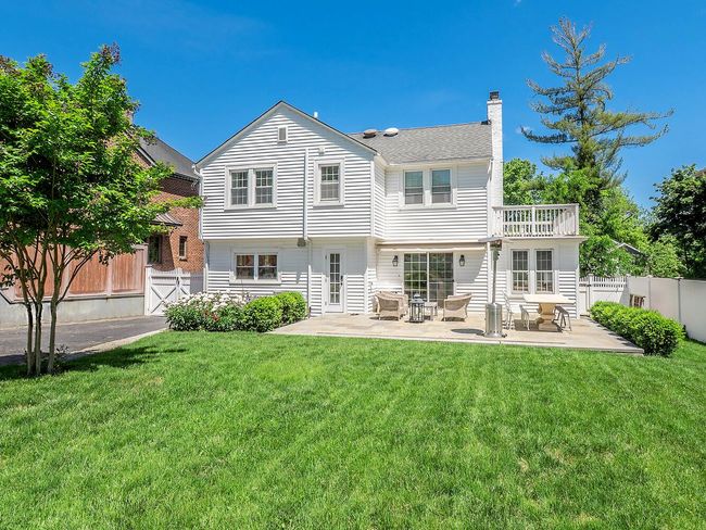 Rear view of house with a chimney, a patio area, and a balcony | Image 22