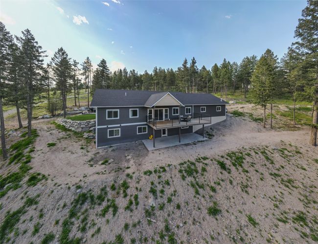 Rear view of property with a patio area, dirt driveway, and a deck | Image 54