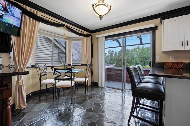 Dining area featuring crown molding, baseboards, and dark stone finish floors | Image 14