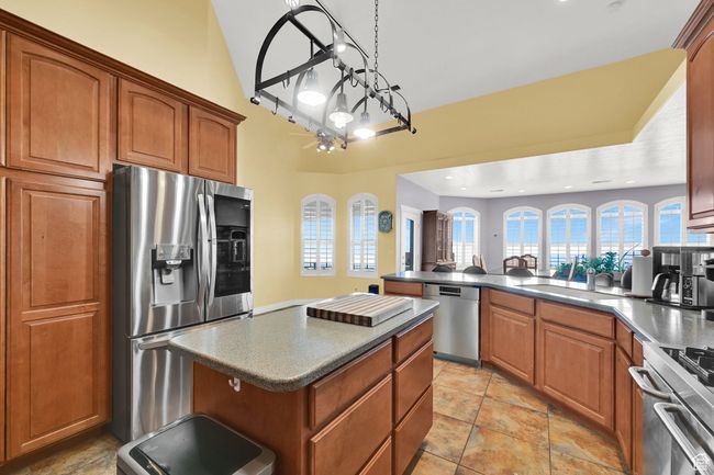 Kitchen featuring a sink, a peninsula, brown cabinets, and appliances with stainless steel finishes | Image 17