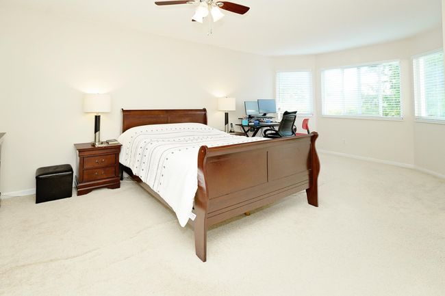 Bedroom with light carpet, an office area, baseboards, and a ceiling fan | Image 23