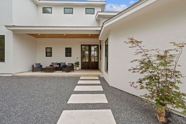 Entry of property featuring an outdoor living space, French front door, a patio area, and stucco siding | Image 4