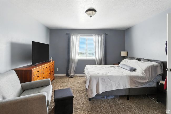 Carpeted bedroom featuring a textured ceiling | Image 18