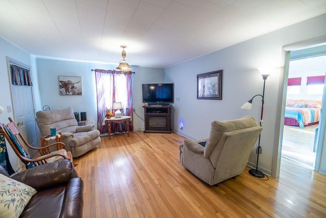 Living room featuring light wood-type flooring and crown molding | Image 9