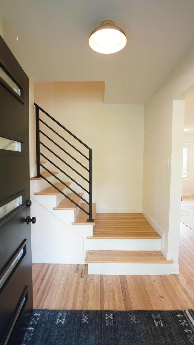 The bold front entry makes an impression with its brand new front door, refinished hardwood floors, new lighting and a custom metal railing. | Image 36
