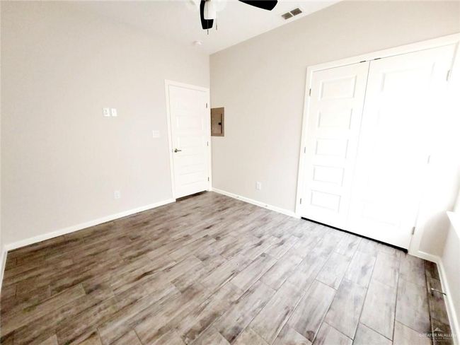Unfurnished bedroom with baseboards, visible vents, a ceiling fan, and wood finished floors | Image 10