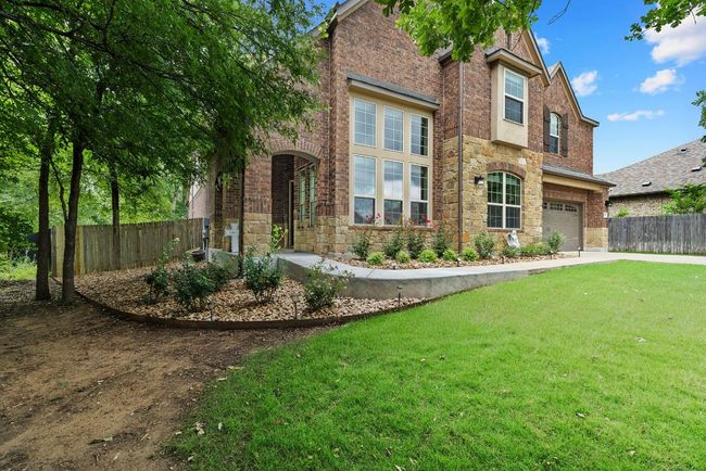 Traditional home featuring a garage, stone siding, brick siding, and concrete driveway | Image 40