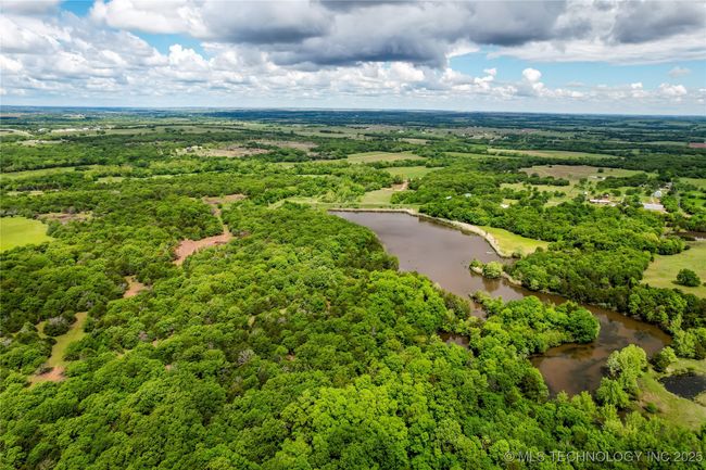 Drone / aerial view of a nearby body of water and a heavily wooded area | Image 58