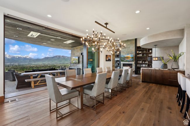 Dining area featuring hardwood / wood-style floors, recessed lighting, a chandelier, a lit fireplace, and a mountain view | Image 11