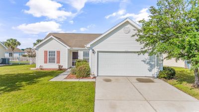 Ranch-style house featuring a garage, central AC unit, and a front yard | Image 2