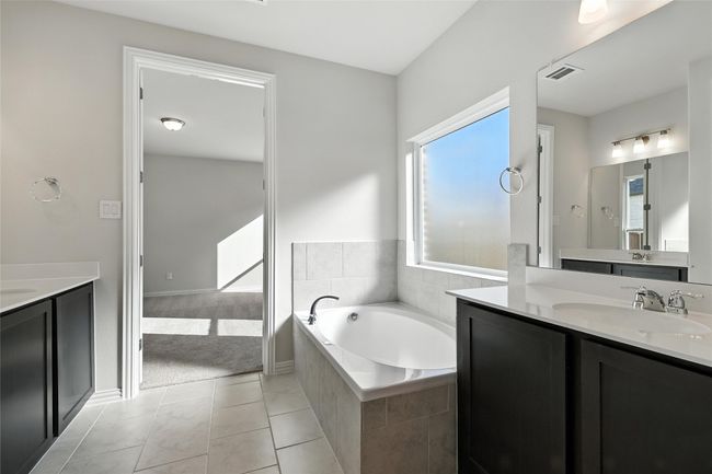 Bathroom with two vanities, a bath, and tile patterned floors | Image 17