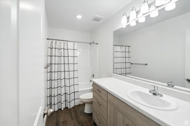 Bathroom with vanity, wood finished floors, shower / bathtub combination with curtain, and recessed lighting | Image 15