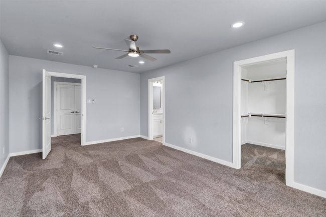 Unfurnished bedroom with carpet, recessed lighting, a walk in closet, connected bathroom, and a ceiling fan | Image 26