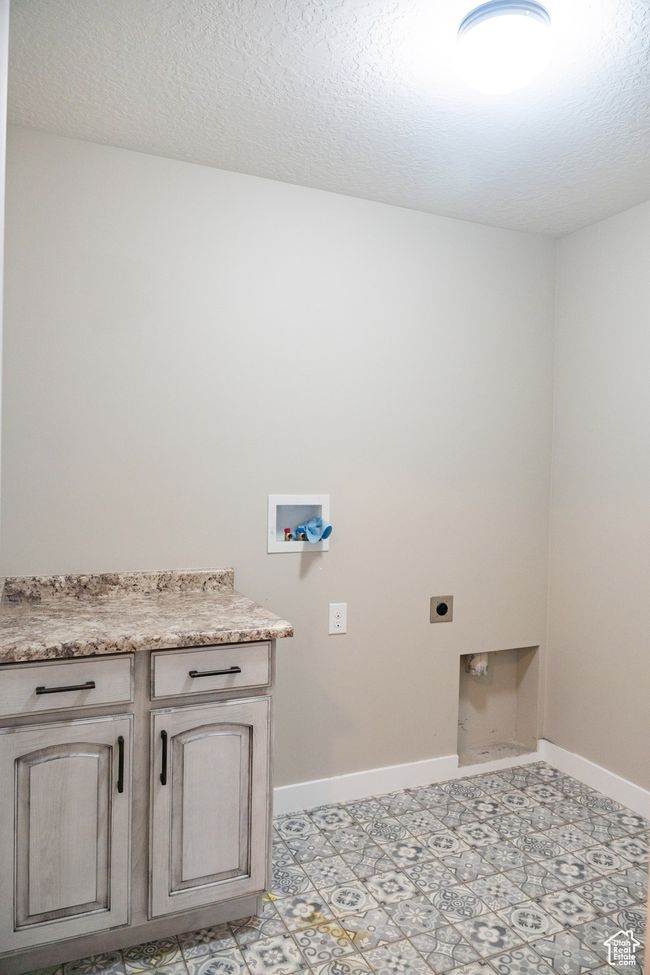 Washroom featuring electric dryer hookup, washer hookup, cabinet space, and a textured ceiling | Image 22