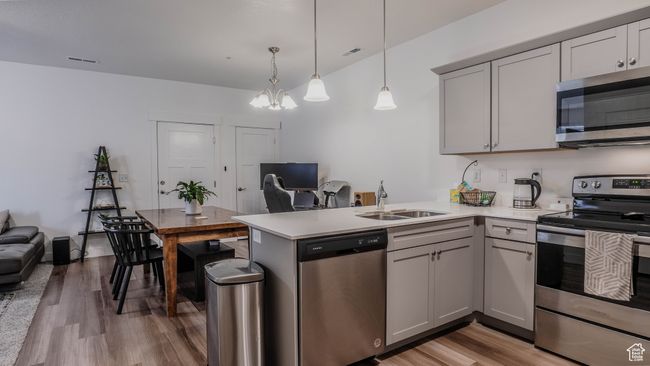 Kitchen featuring a sink, visible vents, light wood-style floors, light countertops, and appliances with stainless steel finishes | Image 13