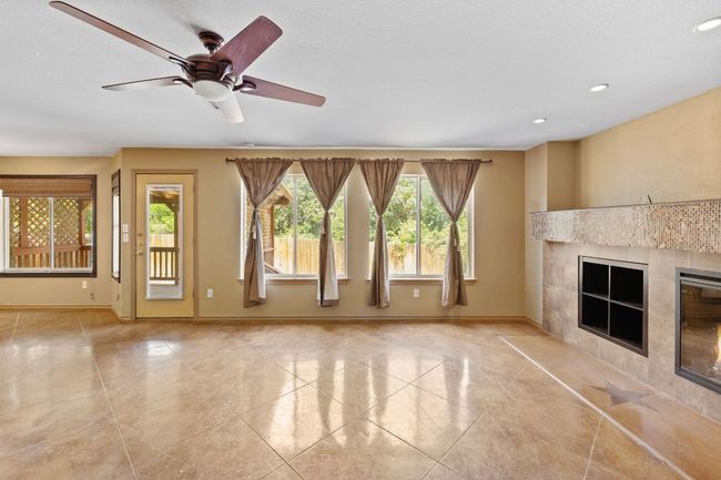 Unfurnished living room with a tiled fireplace, tile patterned floors, recessed lighting, and a ceiling fan | Image 8