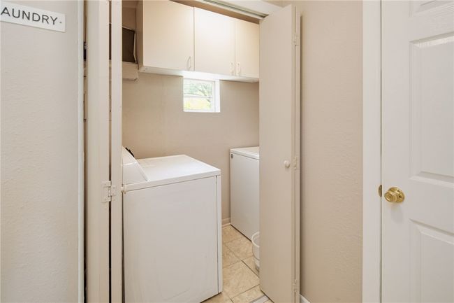 Laundry room featuring washer and clothes dryer, cabinet space, and light tile patterned floors | Image 19