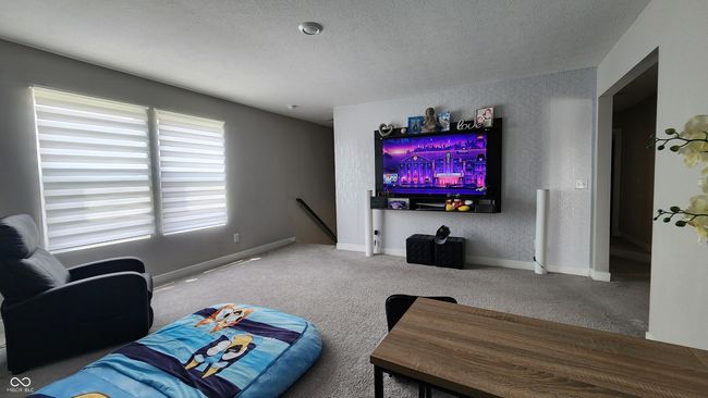living room with carpet floors and a textured ceiling | Image 12