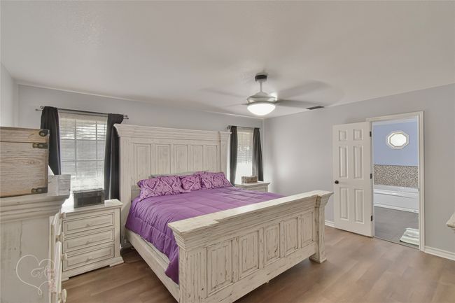 Bedroom featuring wood finished floors, a ceiling fan, and connected bathroom | Image 20