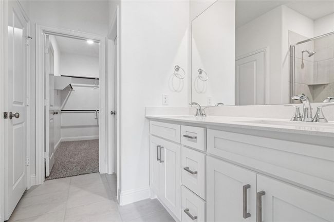 Bathroom with double vanity, light tile patterned floors, a shower stall, and a spacious closet | Image 19