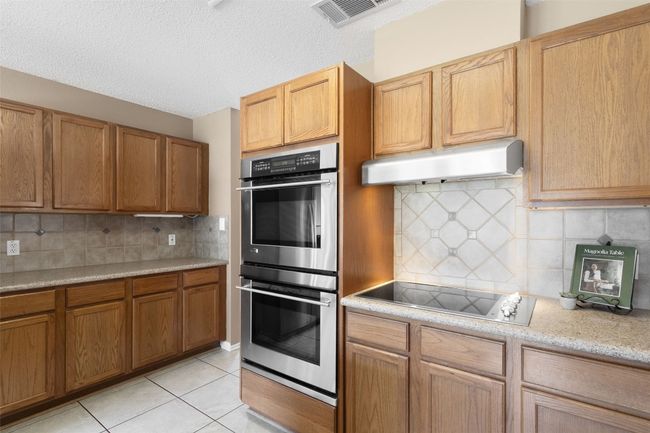 Discover a baker's kitchen featuring double ovens and a stylish backsplash. The granite countertops add a touch of elegance, while the overall design balances functionality with everyday appeal. | Image 21