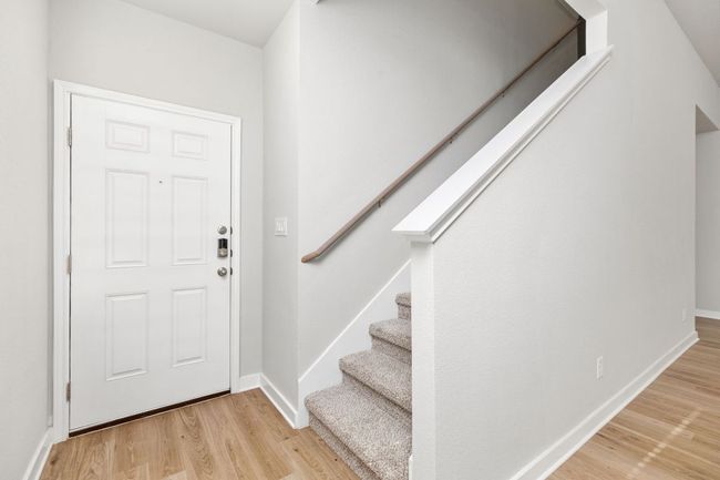 Foyer entrance with stairs, wood finished floors, and baseboards | Image 9