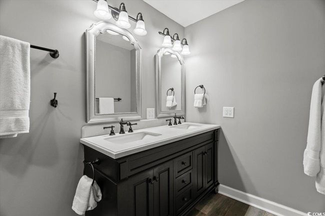 Full bath featuring wood finished floors, baseboards, and double vanity | Image 23