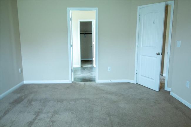 Unfurnished bedroom with carpet floors and a walk in closet | Image 7