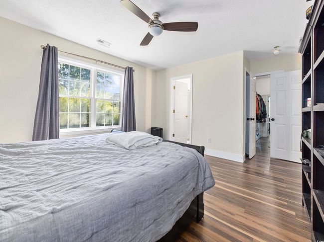 Bedroom with baseboards, visible vents, dark wood-style floors, and ceiling fan | Image 17