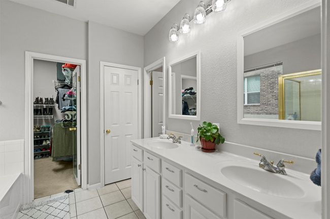 Bathroom featuring double vanity, a sink, a tile shower, and tile patterned flooring | Image 11