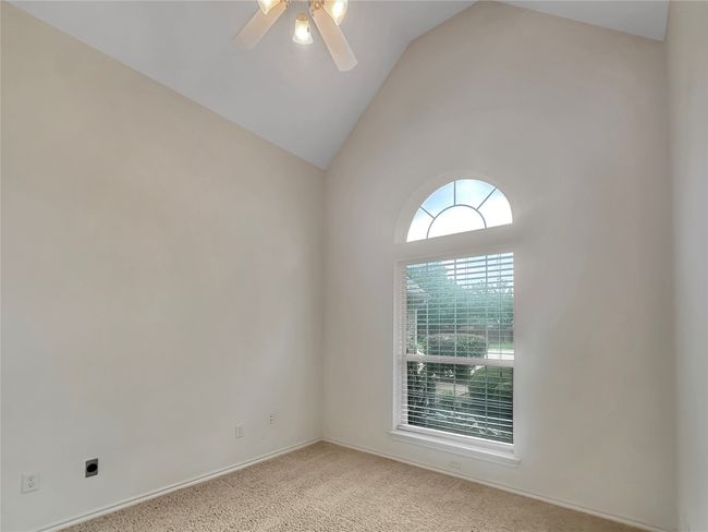 Carpeted spare room with a ceiling fan and high vaulted ceiling | Image 16